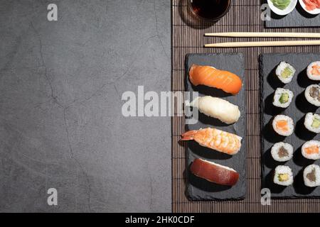 Variété de sushis sur fond sombre.Ensemble sushi avec espace publicitaire. Banque D'Images