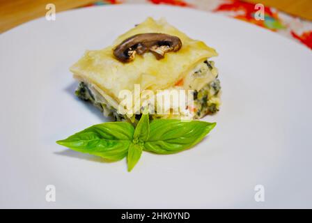 Lasagnes aux légumes crémeuses servies sur une assiette blanche Banque D'Images