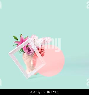 Collage avec plâtre antique sculpture de visage humain dans un style pop art.Concept créatif coloré néon ancienne tête de statue, cheveux faits de fleur fraîche Banque D'Images