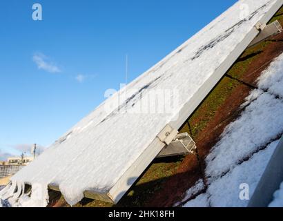 Panneaux solaires enneigés sur le toit d'une maison. Banque D'Images