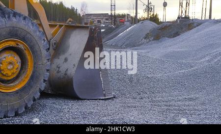 Le tracteur déplace les gravats vers le chariot.Films.La pelle-chargeuse débite les débris du tas sur le chantier et décharge les charges du camion.Site de compensation ou mini Banque D'Images