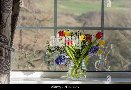 Un vase de fleurs de printemps sur un rebord de fenêtre. Banque D'Images