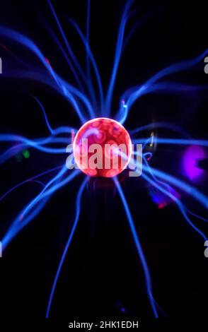 Boule de plasma avec des éclairs irisés dans différentes couleurs sur un fond très sombre Banque D'Images