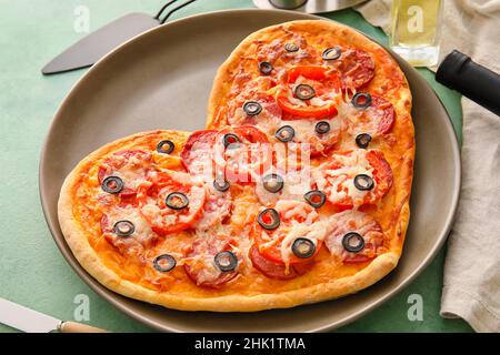 Assiette avec pizza savoureuse en forme de cœur sur la table.Célébration de la Saint-Valentin Banque D'Images