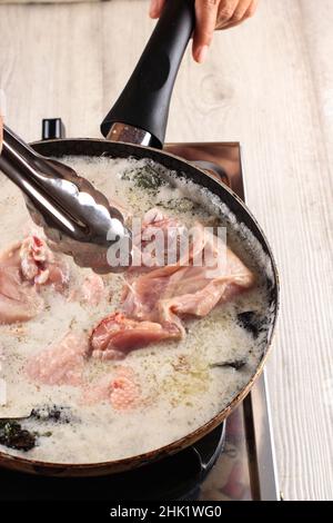 Poulet grillé aux herbes et aux épices (Ungkep Ayam), cuisson dans la cuisine préparation du poulet frit traditionnel indonésien Banque D'Images