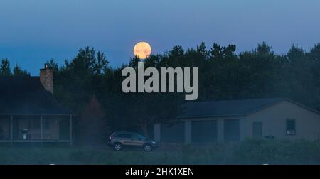 La pleine lune qui se trouve au-dessus d'une ferme dans le nord du Wisconsin. Banque D'Images