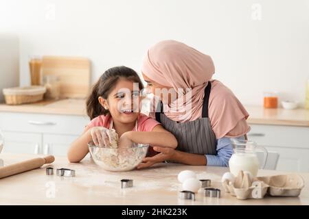 Activités en famille.Bonne mère musulmane dans hijab pâtisserie avec petite fille mignonne Banque D'Images