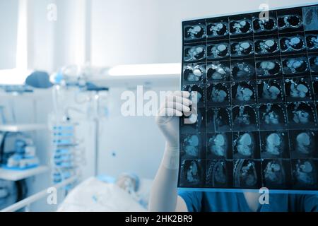 Le médecin féminin examine l'image scanner des organes thoraciques du patient dans la chambre d'hôpital. Banque D'Images