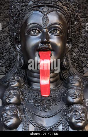 Statue noire de la déesse hindoue Kali avec une langue rouge qui goute le sang: À l'extérieur d'un magasin d'objets religieux à Bamrung Muang Road, Bangkok, Thaïlande Banque D'Images