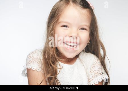 Adorable petite fille qui met un sourire radieux sur son visage accompagné de sa beauté qui illumine le monde comme un rayon de soleil. Banque D'Images