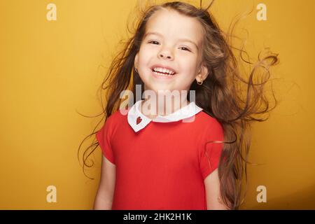 Adorable petite fille qui met un sourire radieux sur son visage accompagné de sa beauté qui illumine le monde comme un rayon de soleil. Banque D'Images