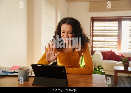 Femme d'affaires afro-américaine travaillant à domicile et agitant sur une tablette numérique lors d'un appel professionnel Banque D'Images
