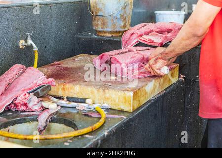 Moyen-Orient, Péninsule arabique, Oman, Muscat, Muttrah.Préparation du thon frais à la vente au souk de poisson de Muttrah.(Usage éditorial uniquement) Banque D'Images