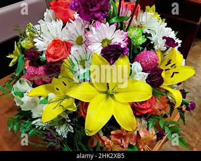 Magnifique arrangement de fleurs de Pâques avec des lys jaunes, des pâquerettes, des roses et d'autres fleurs. Banque D'Images