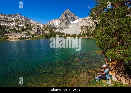 Eau d'épuration des randonneurs sur les rives du lac Treasure, John Muir Wilderness, Sierra Nevada Mountains, Californie, États-Unis. Banque D'Images