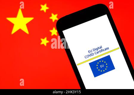 Sur cette photo, un logo du certificat de vaccination numérique contre les covidés de l'UE apparaît devant un drapeau national chinois. Banque D'Images