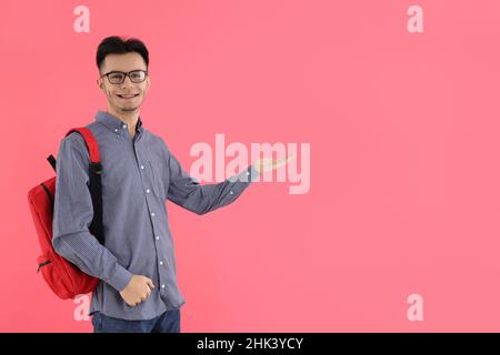 Étudiant avec sac à dos sur fond rose Banque D'Images