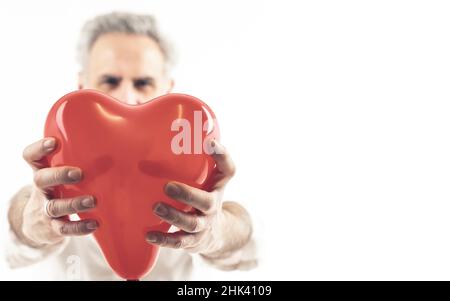 Homme à poil gris tenant un boron en forme de coeur - isolé sur fond blanc.Photo de haute qualité Banque D'Images