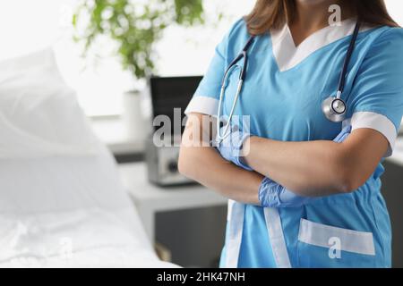 Femme médecin avec bras croisés debout dans la salle d'hôpital de près Banque D'Images
