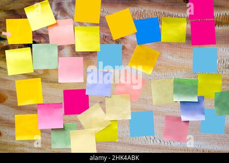 Papier vierge multicolore autocollant sur panneau en bois pour écrire une courte note pour rappel une liste de tâches Banque D'Images