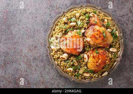 Poulet libanais servi sur un lit de blé vert séché au feu avec une garniture de noix grillées sur la table.Vue horizontale du dessus Banque D'Images