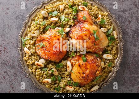 Assiette de Freekeh syrien traditionnel avec poulet rôti et amande sur la table.Vue horizontale du dessus Banque D'Images