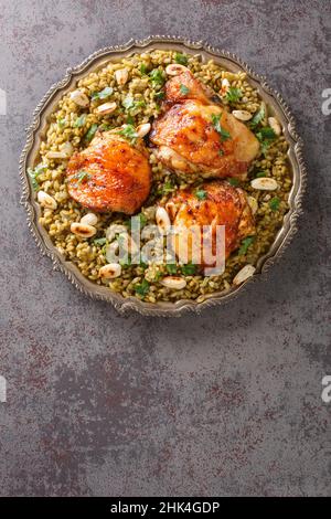 Freekeh avec poulet, amandes populaires cuisine libanaise gros plan dans une assiette sur la table. Vue verticale du dessus Banque D'Images