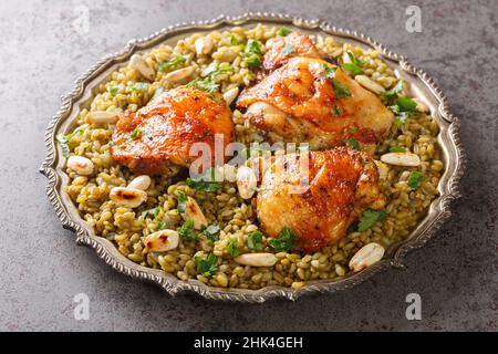 Assiette de Freekeh syrien traditionnel avec poulet rôti et amande sur la table.Horizontale Banque D'Images