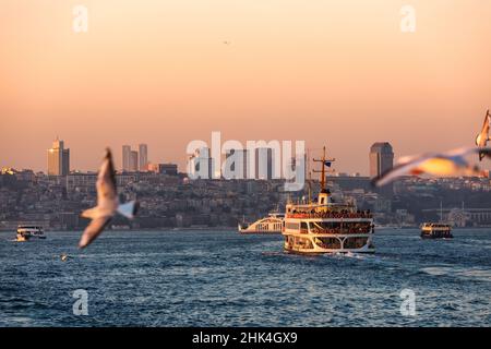 Bateaux-ferries pour passagers traversant Bosporus ou le détroit d'Istanbul au coucher du soleil.Beyoglu district est vu en arrière-plan Banque D'Images