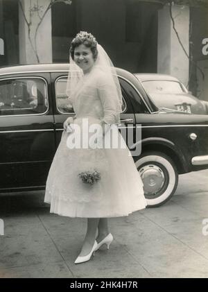 Mariage en Italie au cours de la 1950s: La mariée arrive à l'église avec la voiture Banque D'Images