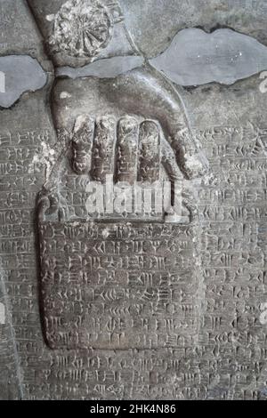 Relief antique représentant un seau d'eau sainte, porté par un génie ailé avec l'écriture cuneiform.Civilisation assyrienne et sumérienne (883-859 BCE). Banque D'Images