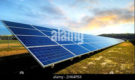 Panneaux solaires au coucher du soleil. Paysage industriel avec centrale photovoltaïque. Concept environnemental. Solar Farm produit de l'énergie verte alternative. Banque D'Images