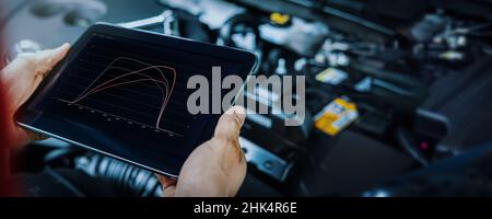 remise en correspondance et diagnostic de l'ecu du moteur de la voiture. mécanicien utilisant une tablette numérique pour vérifier les performances du véhicule après le réglage du chiptuning Banque D'Images