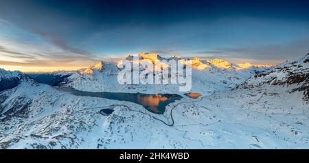 Route sinueuse du col de Bernina dans le paysage d'hiver près du Lago Bianco gelé au lever du soleil, Engadine, Graubunden, Suisse, Europe Banque D'Images