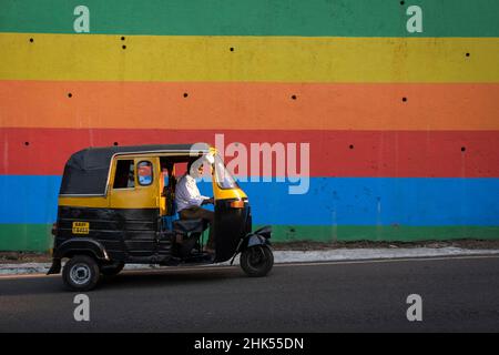 Tuk Tuk indien passant devant un mur peint aux couleurs vives dans la ville de Panjim, Panjim (Panaji), Goa, Inde, Asie Banque D'Images