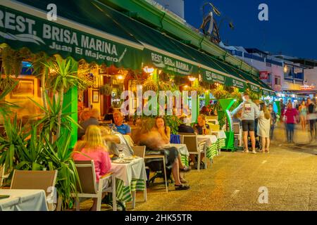 Vue sur les restaurants et les magasins surplombant la plage Playa Blanca au crépuscule, Playa Blanca, Lanzarote, îles Canaries, Espagne,Atlantique, Europe Banque D'Images