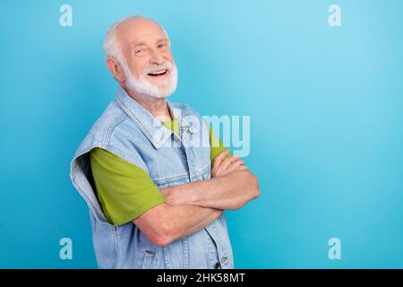 Photo de l'homme confiant et original retraité habillé denim rétro veste bras croisés espace vide sourire isolé couleur bleu fond Banque D'Images