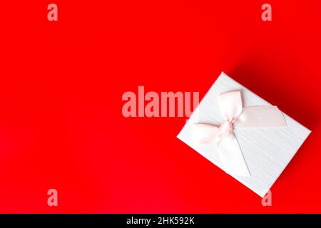 Boîte cadeau sur fond rouge.St. RomantiqueLe concept de la Saint-Valentin de salutations. Lieu pour votre texte Banque D'Images