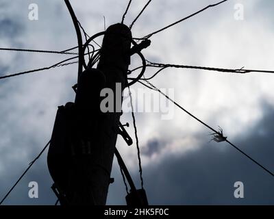 Ici, nous voyons un poteau transportant des câbles assortis lors de ma promenade quotidienne à travers Lower Radley jusqu'à la Tamise; tourné sous un ciel luciant. Banque D'Images