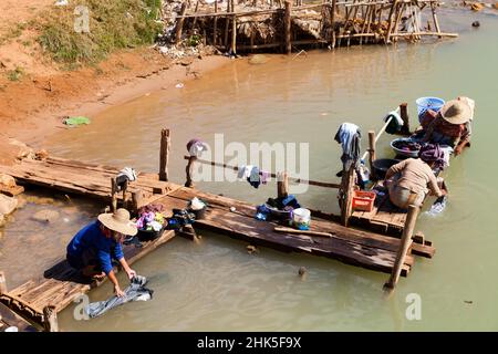 Une scène intemporelle de femmes, d'enfants et de washday au bord de la rivière à l'Inn Thein, un village Intha dans le centre du Myanmar.Il est probablement resté inchangé pour Banque D'Images