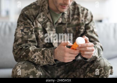 Soldat méconnaissable portant un pot avec des médicaments, écourté Banque D'Images