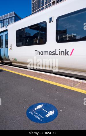 Classe 700 train de Desiro City à Thameslink dans une gare du Royaume-Uni, avec des marques de distance sociale sur la plate-forme. Banque D'Images