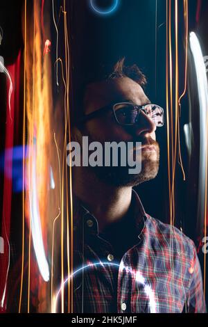 Un homme plein de confiance entre dans le métaverse par le biais d'un portail virtuel, projeté sous forme de lumières et d'effets futuristes sur l'espace-temps Banque D'Images