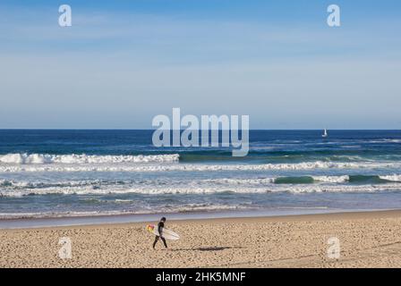 Surfeur avec surf marche sur la plage de Zurriola à San Sebastian, Espagne Banque D'Images