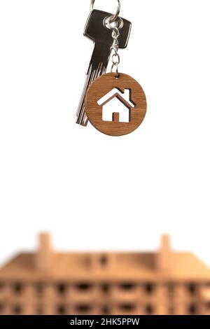 Concept immobilier.Clés avec porte-clés en forme de maison contre modèle brun. Banque D'Images