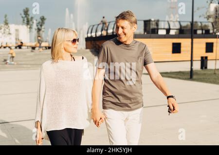 Un adulte mature heureux couple romantique amoureux en plein air dans le parc de rue de la ville.Un homme blanc blond et une femme passent du temps ensemble.Femme senior et Banque D'Images