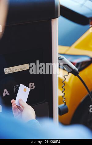 Payer pour charger la voiture électrique avec carte de paiement sans contact dans la rue Banque D'Images