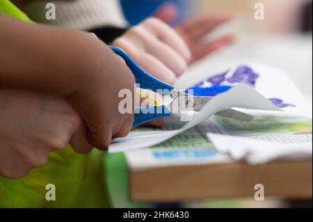 Darmstadt, Allemagne.02nd févr. 2022.Un enseignant coupe quelque chose avec un enfant dans une garderie.Credit: Sebastian Gollnow/dpa/Alay Live News Banque D'Images