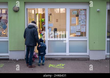 Darmstadt, Allemagne.02nd févr. 2022.Un père apporte ses enfants à une garderie.Il doit les laisser à la porte et n'est pas autorisé à entrer dans les chambres en raison des mesures contre le coronavirus.Credit: Sebastian Gollnow/dpa/Alay Live News Banque D'Images