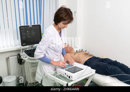 Équipement médical pour électrocardiogramme.Médecins effectuant un test ECG sur un patient masculin.Diagnostic de maladie cardiaque crise cardiaque, tachycardie.Electrocardiograp Banque D'Images